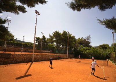 Giocare a tennis sotto i pini