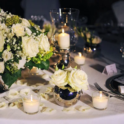 Svečano okrašena miza z belim cvetjem in svečami med silvestrovanjem v Hotelu Kimen